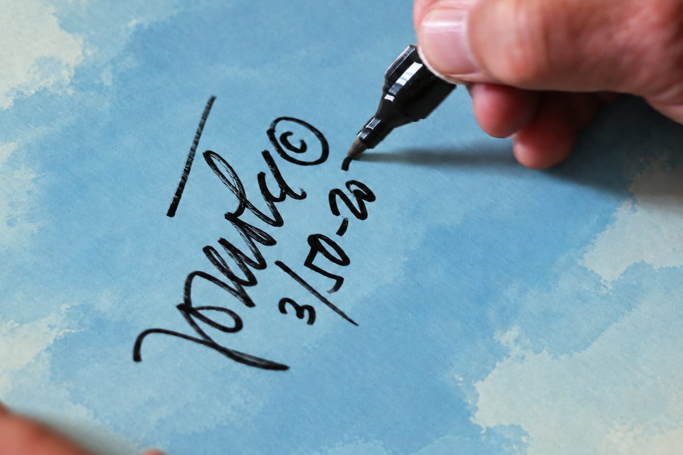 Close-up of Jože Trobec hand-signing and numbering a Vučko Ski Jumper print
