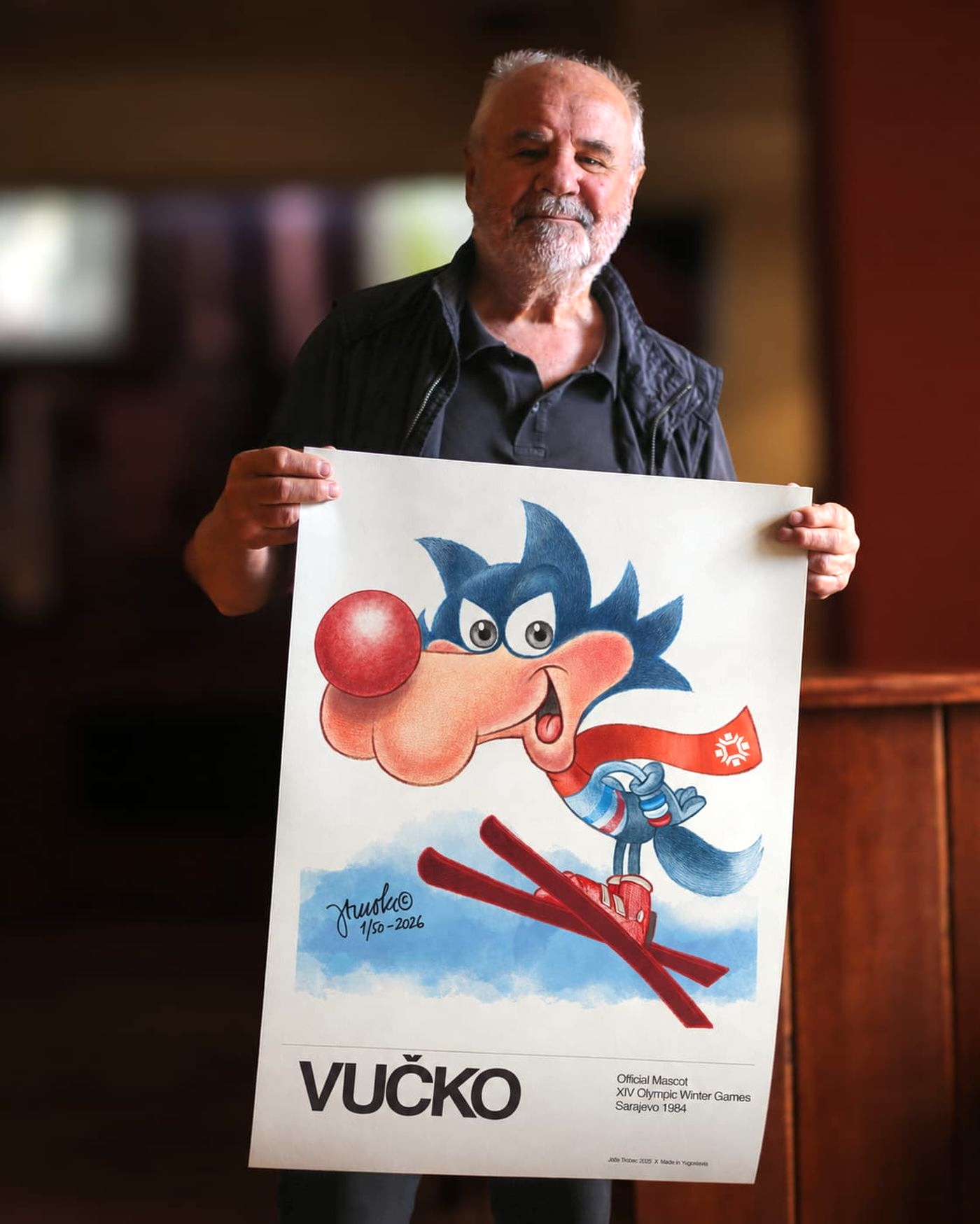 Jože Trobec, the artist who created Vučko, holding the signed Ski Jumper print